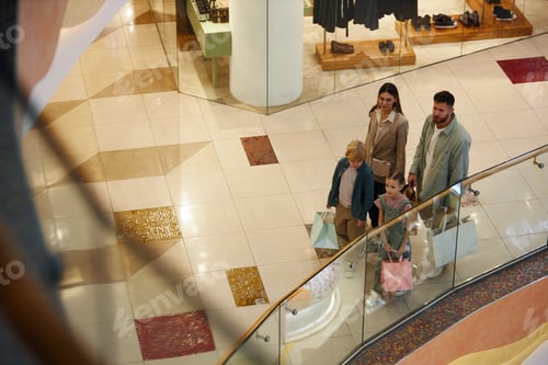 Preview: Family with Two Kids with Bags Walking in Shopping Center
