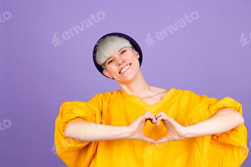 Preview: Stylish european woman on purple background shows heart with hands love concept copy space