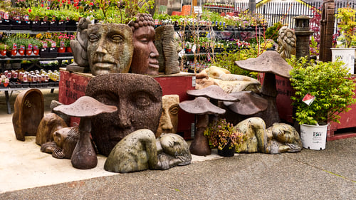 Preview: Numerous garden ornaments and bedding plants for sale at a garden center.