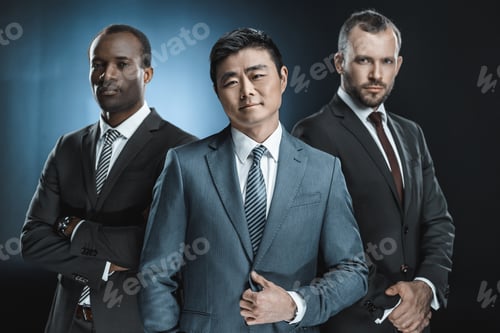 Preview: portrait of multicultural confident businessmen in suits looking at camera isolated on black