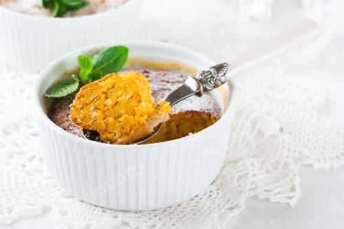 Preview: Cheese Casserole with pumpkin and cinnamon for breakfast in a white ceramic form on a light backgrou