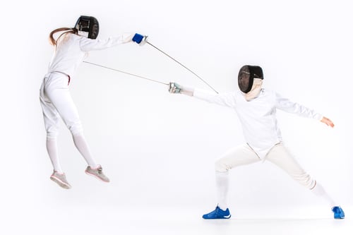 Preview: The woman and man wearing fencing suit practicing with sword against gray