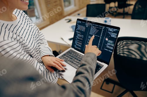 Preview: Close up of female computer programmers is coding at laptop while standing in coworking