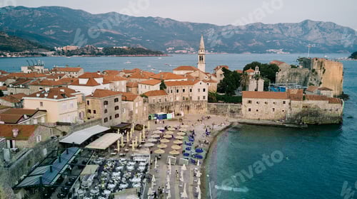 Preview: Beach near the stone fortress walls of the old town of Budva on the seashore. Montenegro. Drone