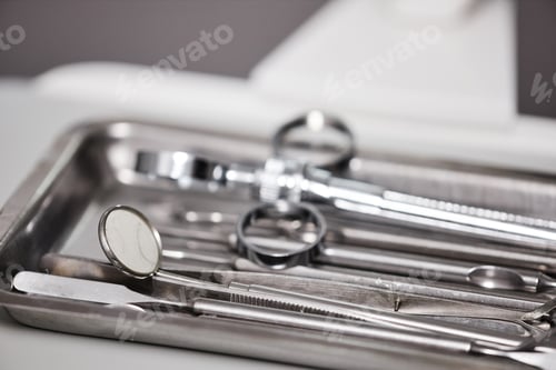 Preview: Closeup of sterile tools in metal tray on table in dental clinic