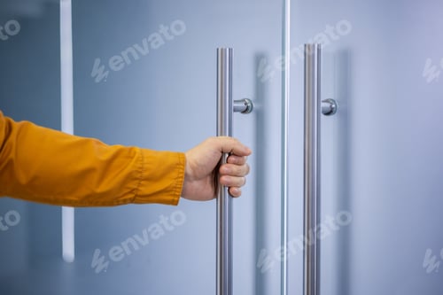 Preview: Person opening a glass door with a modern handle
