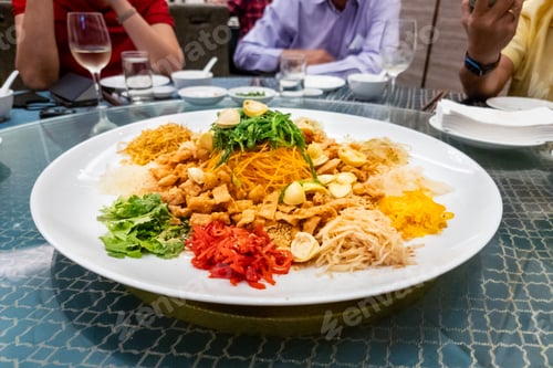 Preview: Serving of auspicious yusheng or yee sang with abalone in restaurant during Chinese New Year