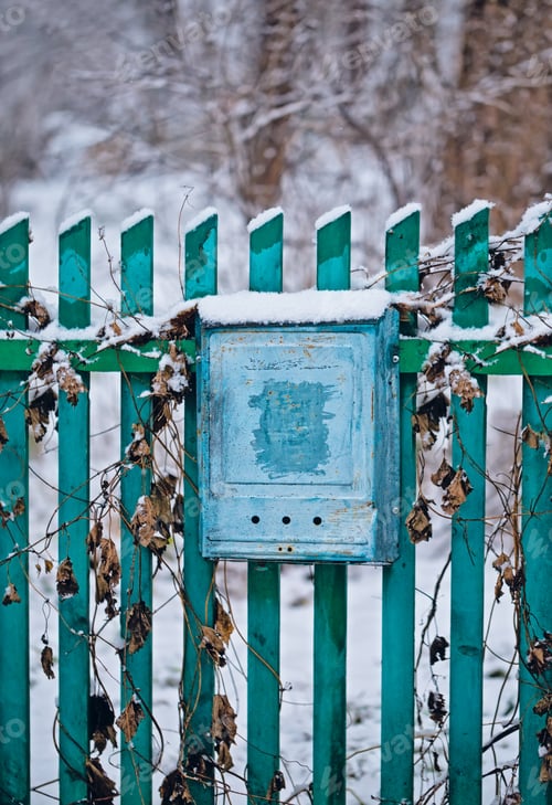 Preview: Close up of a mailbox on the street with blue fence