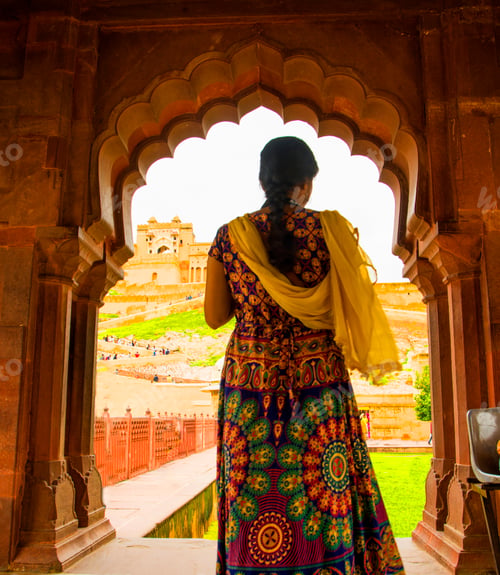 Preview: Woman tourist taking a photo of the Amer fort, located in Jaipur, India.
