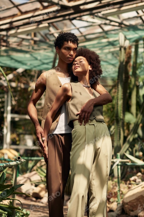 Preview: Young couple shares a tender moment in a lush greenhouse surrounded by vibrant greenery