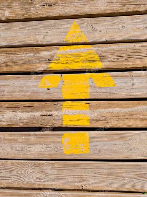 Preview: Yellow painted arrow pointing up on wooden wall
