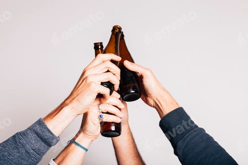 Preview: hands holding a bottle of beers and toasting up