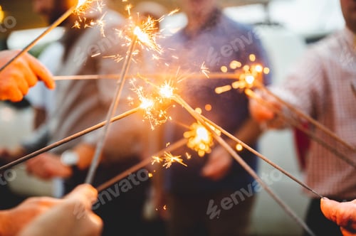 Preview: Group of people holding burning Bengal lights at the party