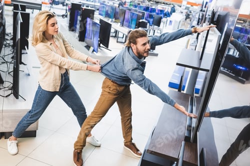 Preview: girlfriend pulling sad boyfriend with tv in home appliance store