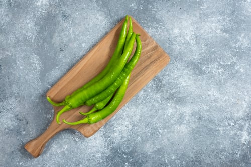 Preview: Green chili peppers on wooden board