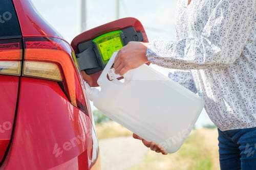 Preview: Close up woman refilling the red car with fuel or a diesel engine fluid from canister in the field.