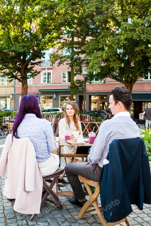 Preview: Friends talking at sidewalk cafe in town square