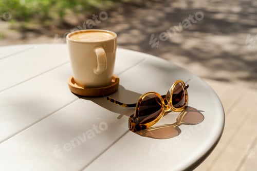 Preview: Eyeglasses and cup of coffee on wooden table. Travel, vacation concept.