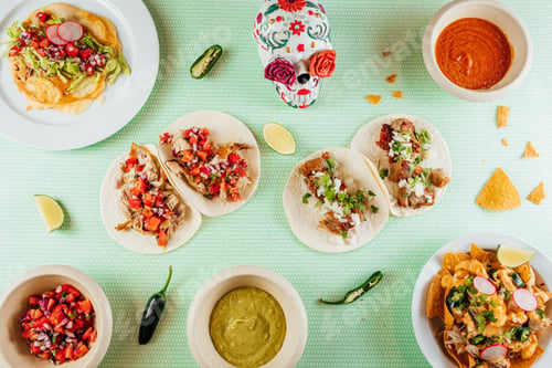 Preview: Top view of tortilla wraps surrounded with different dishes on a table