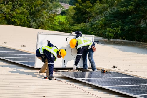 Preview: Solar panels installation. Construction workers with safety hardhat working on roof
