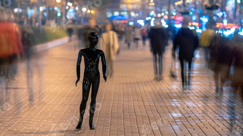 Preview: The black mannequin standing on the evening street with people