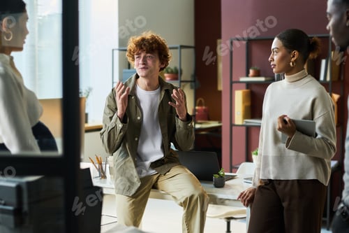 Preview: Male manager chatting to colleagues
