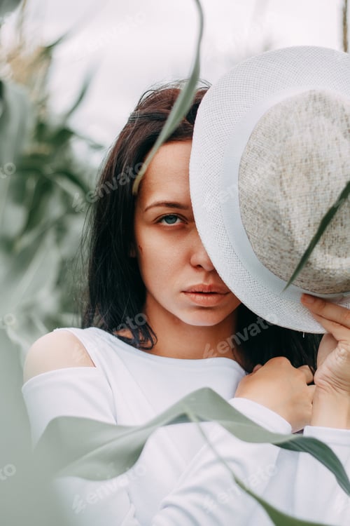 Preview: A brunette girl in a white dress in a cornfield. The concept of harvesting.