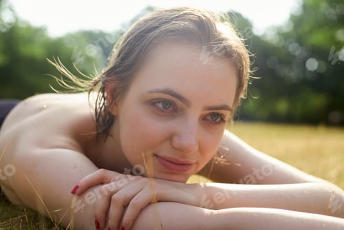 Preview: Woman Lying Outdoors on Grass in a Field