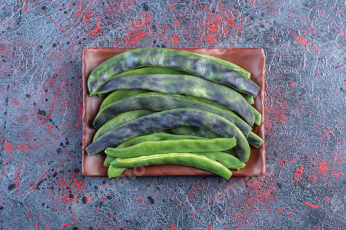 Preview: Small pile of bean pulses on a platter on dark colored background