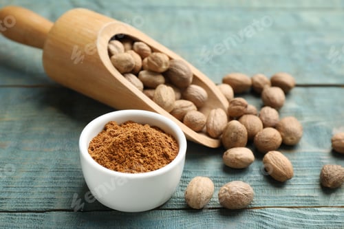 Preview: Bowl of nutmeg powder and scoop with seeds on light blue wooden table