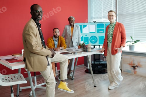 Preview: Diverse Team Posing in Modern Office with Digital Screen