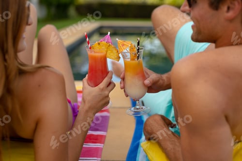 Preview: Happy young couple relaxing near the swimming pool