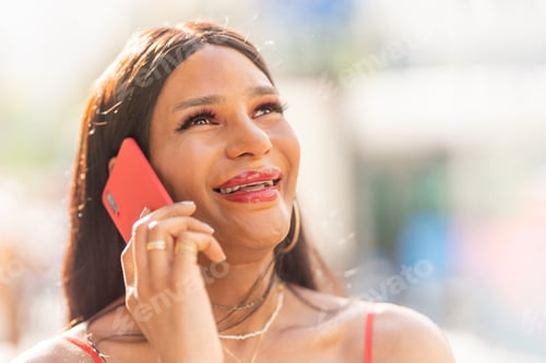 Preview: Smiling Adult Talking on a Red Cellphone Outside