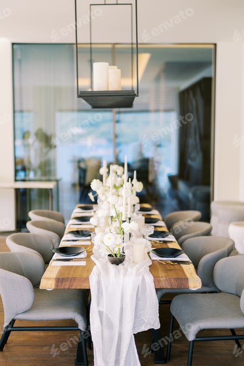 Preview: Festive table with white flowers and black crockery in a restaurant with candles on a hanging shelf