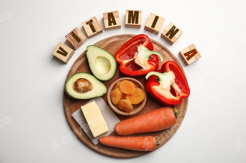 Preview: Cubes with phrase VITAMIN A and fresh products on white table, flat lay