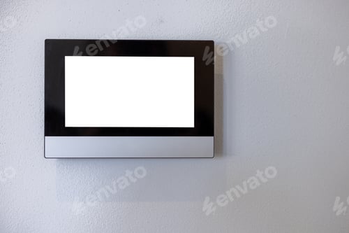 Preview: Smart home system control panel on a white wall of a living room or office. With a white screen as