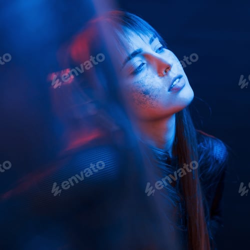 Preview: Sensuality and enjoyment. Studio shot in dark studio with neon light. Portrait of young girl