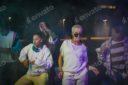 Preview: Group of young people with modern outfits in the street with neon lights at night