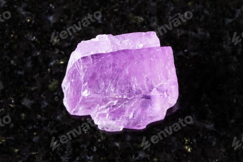 Preview: sample of rough kunzite crystal on black granite