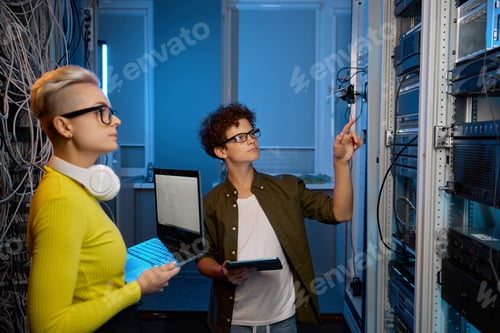 Preview: Serious technicians working together with network hardware
