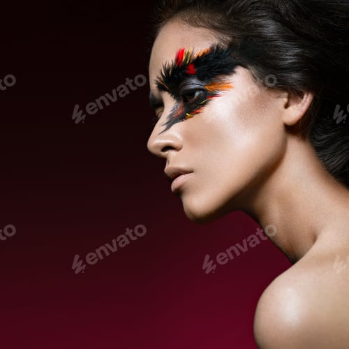 Preview: Beautiful girl in image of Phoenix bird with creative makeup. beauty face.