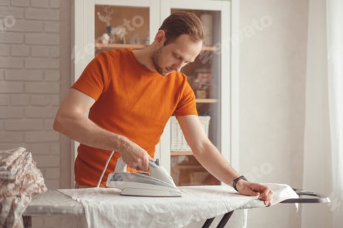 Preview: Man with Brown Hair Ironing Clothes Indoors