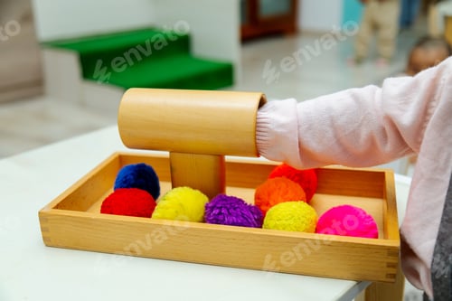 Preview: Close up of toddler playing with montessori pompom material