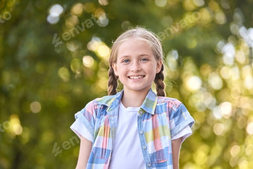 Preview: Smiling caucasian young girl outdoors in nature with braided hair and colorful