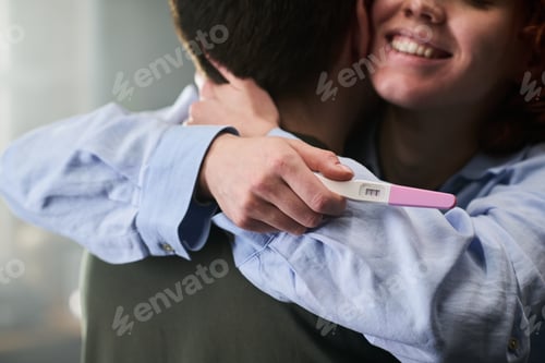 Preview: Young Woman Hugging Man While Showing Positive Pregnancy Test