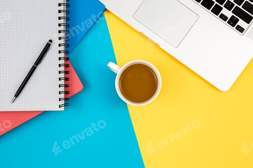 Preview: Notebooks, laptop and cup of coffee on a blue and yellow background.