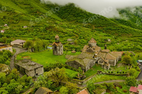 Preview: Drone view of Haghpat monastery on top of a green hill full of houses in Armenia