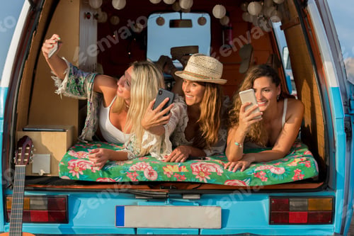 Preview: Three friends taking a selfie while lying inside a van