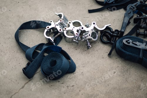 Preview: Rigging clamps and straps lying on concrete floor