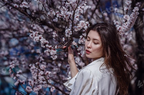 Preview: young asian woman in a flowering garden